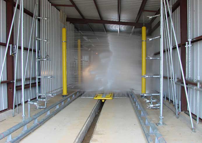 A drive through truck wash system with water spraying.