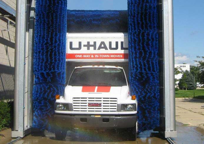 A U Haul van going through a roll over truck wash system.