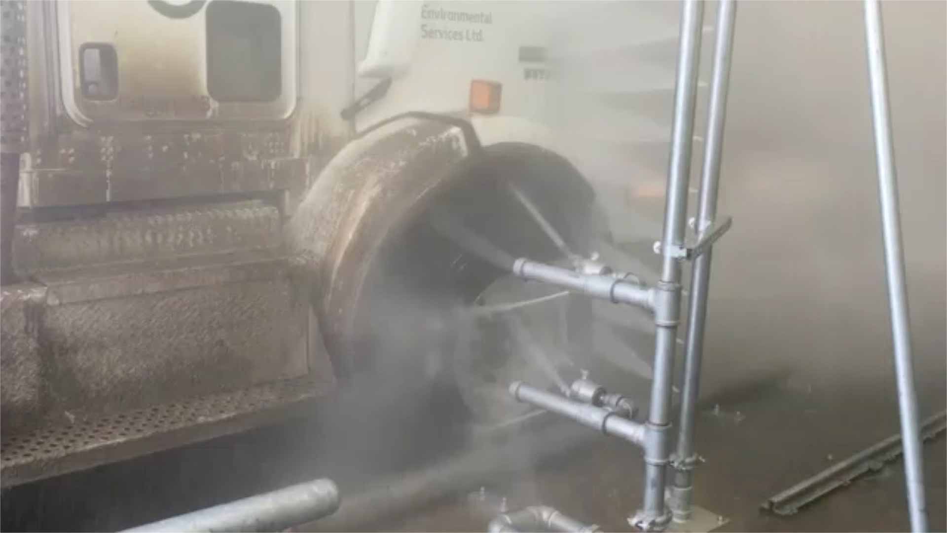 A high-pressure washing system cleaning a truck.