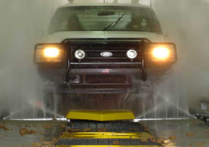 A vehicle being washed by fleet wash system.