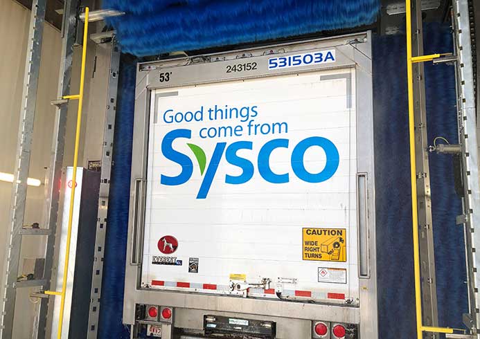 A truck going being washed in a roll-over truck wash system.