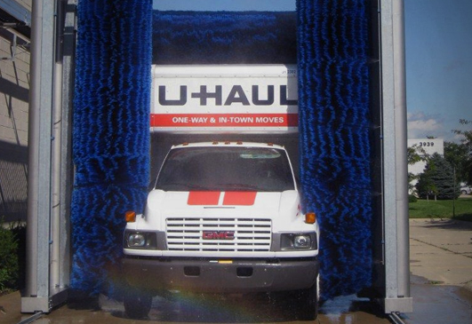 A U-Haul truck going through a truck wash system.