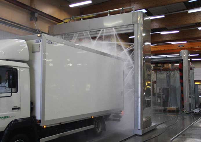 A semi-truck going through a vehicle wash system.