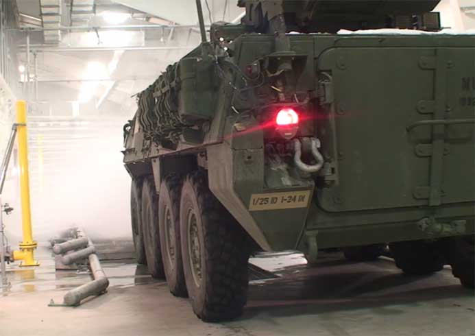 A military tank going through a military vehicle wash system.