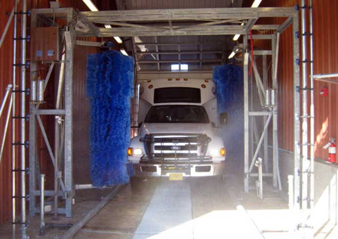 A transit bus being washed by a bus wash system.